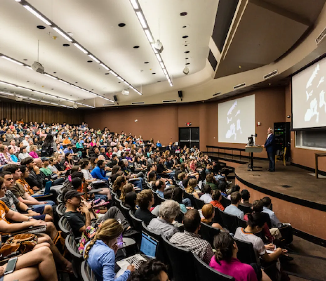 Professor Neil Shubin delivers a lecture to a large audience of college students at the University of Texas at Austin.