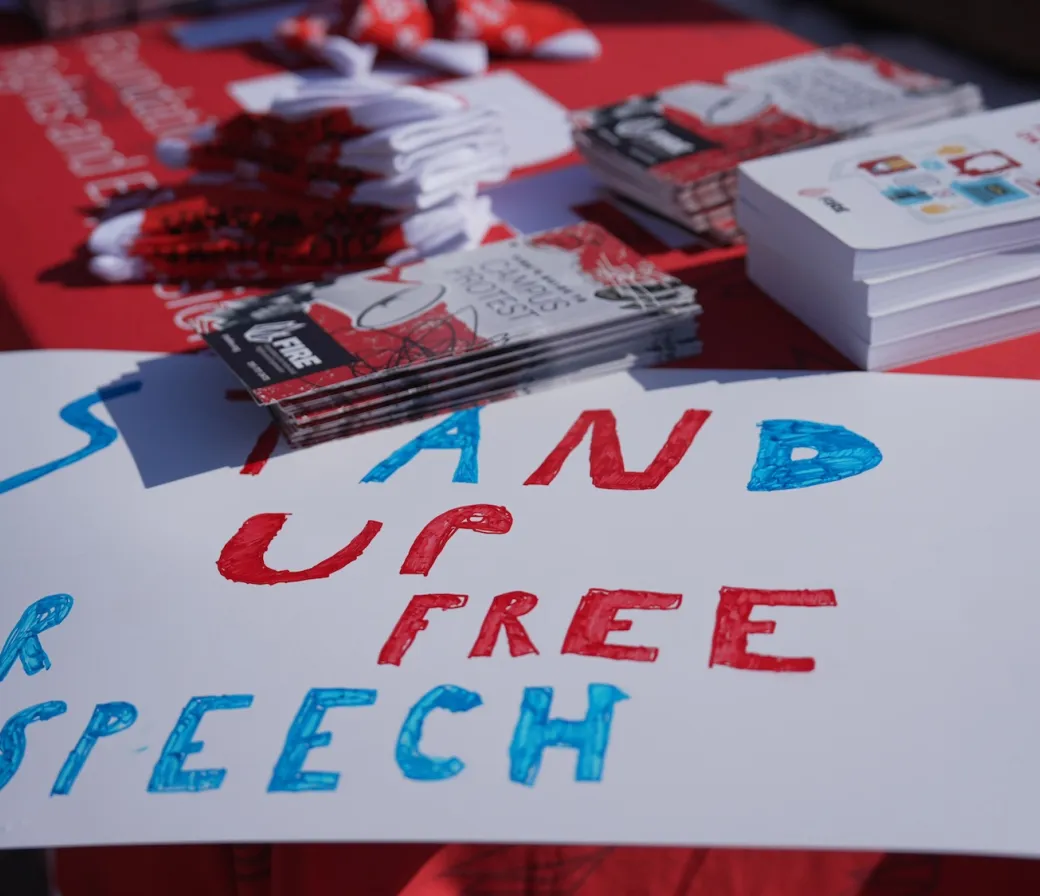 FIRE table at University of Illinois Urbana Champaign with a sign on the corner that reads "stand up for free speech". Photography by Sylwia Sawicka.