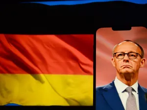 German Chancellor Friedrich Merz on a phone screen with German flag in the background