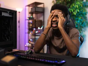 Shocked young black man looking at his computer screen