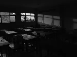 A darkened classroom with open windows