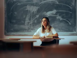 Frustrated schoolteacher sitting at her desk