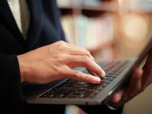 student reads study on laptop