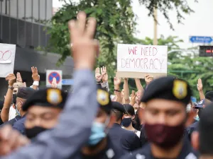 Protesters give 3-finger salute as they march during an anti-government mass protest in Bangkok Thailand. (Image via Shutterstock.com)