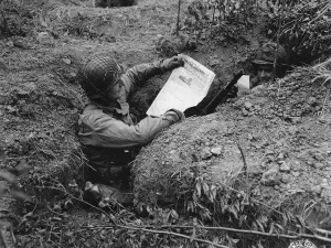 soldier in foxhole reading paper