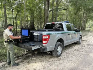 An FWC officer readies a drone at the back of his truck