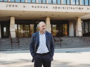 FIRE plaintiff Michael Balow standing in front of the John Hannah Administration Building at Michigan State University