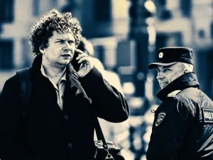 Man on phone in Moscow walks past police officer