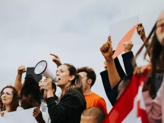 protesters marching and one holding a megaphone