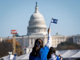 A child waves the flag of Israel at a rally during the March for Israel in Washington on the National Mall 