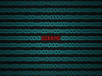 Computer screen with binary code and the word DOXXING in red