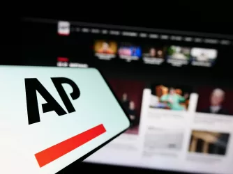 Logo of news agency Associated Press on screen in front of website (T. Schneider / Shutterstock.com)