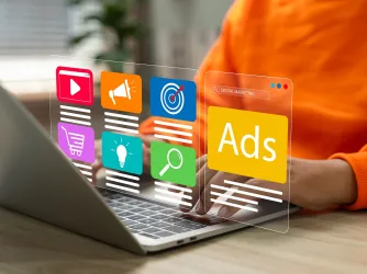 Person at a computer with a digital display showing advertisements