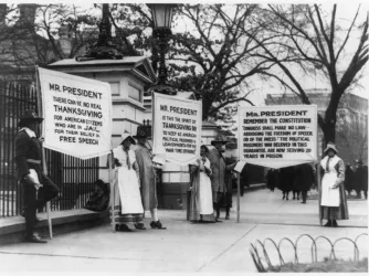 Protesters dressed as pilgrims carry signs calling for amnesty for political prisoners standing in front of the White House, circa 1918.