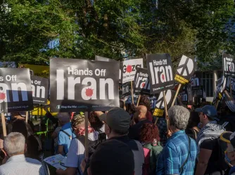 Protesters gather with Palestinian flags and "Hands Off Iran" signs during a demonstration near the US Embassy in London.