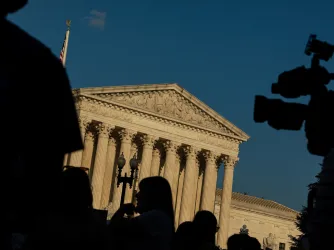 Supreme Court Building in Washington DC with TV camera black Silhouettes in foreground