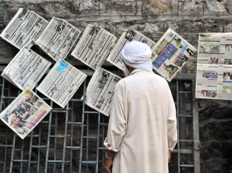 Man reads newspaper in Abbottabad, Pakistan.