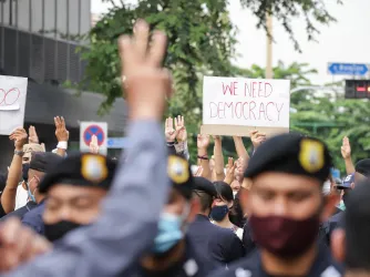 Protesters give 3-finger salute as they march during an anti-government mass protest in Bangkok Thailand. (Image via Shutterstock.com)