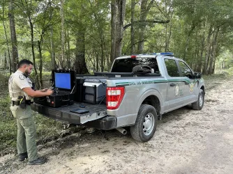 An FWC officer readies a drone at the back of his truck