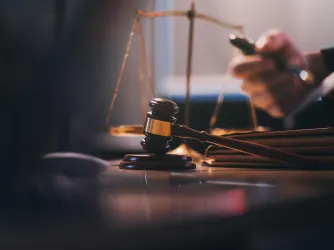 Lawyers having team meeting at law firm background. (Image via Shutterstock.com)