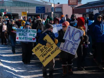 Minnesota protesters stand on the street holding signs