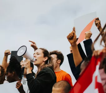 protesters marching and one holding a megaphone