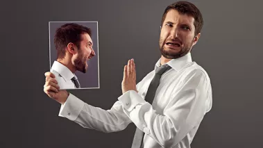 Photo of a man holding a photo of himself looking angry