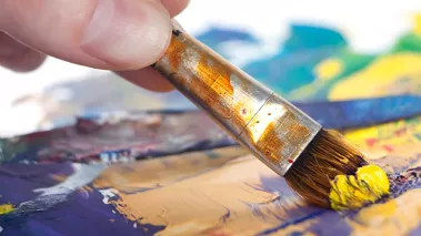 Paint brush applying paint to a canvas.