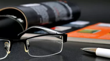 Magazine with glasses and ball pen (Shutterstock.com)