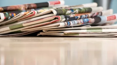 newspapers stacked on a table