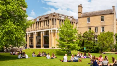 students sitting on the grass on campus
