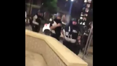 A picture showing an Ohio police officer in riot gear spraying pepper spray into the camera held by a student reporter.