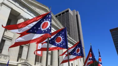 Ohio flags waving in front of the Statehouse in Columbus