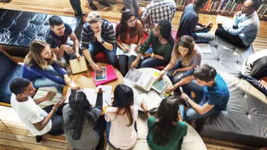 College students studying around a table in a common area.