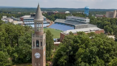 Aerial view of the University of North Carolina campus at Chapel Hill with the belltower in the foreground and stadium in the background