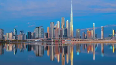 View on Dubai skyline with reflection in the river at sunrise, Dubai, United Arab Emirates