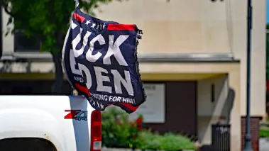 Flags saying fuck Biden and those that voted for him flying from back of pickup truck.