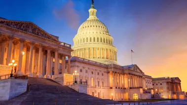 The United States Capitol building with the dome lit up at night.
