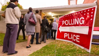 Voting polling place sign and people lined up on presidential election day 