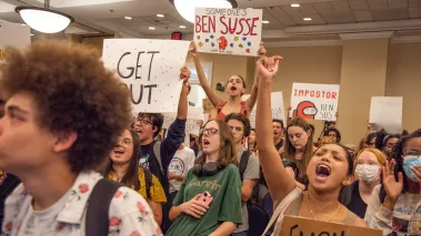 Student protestors wave signs and chant as they enter Sen. Ben Sasse open forum discussion at Emerson Alumni Hall during in Gainesville