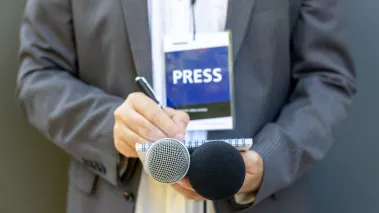 reporter with press badge taking notes