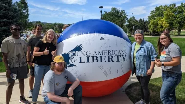 Members of Young Americans for Liberty at Black Hills State University standing in front of a giant beach ball