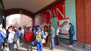 View of the campus of Brown University with students walking through a hallway.