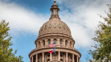 Texas State Capitol Building in Austin with the flag of Texas and the USA 