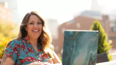 Lorie Smith, owner of 303 Creative, smiles while typing on her laptop