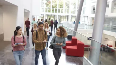 Students walk and talk using mobile devices in university