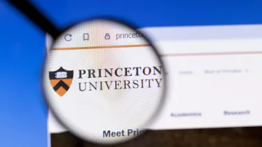 Princeton University website homepage logo visible on display screen under a magnifying glass