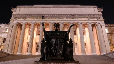 Alma Mater on the steps of the Columbia University library at night
