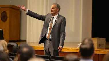UW-La Crosse professor Joe Gow gestures to an audience in an auditorium on campus