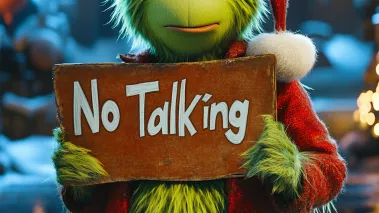 Green Seuss inspired grinch character holding a "No Talking" sign